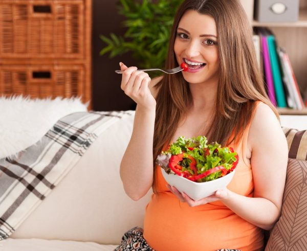 pregnant-smiling-woman-eating-salad